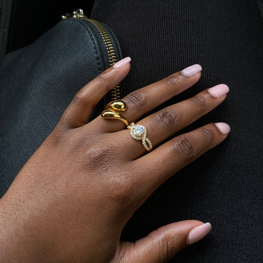 Hand with a gold ring on a black background