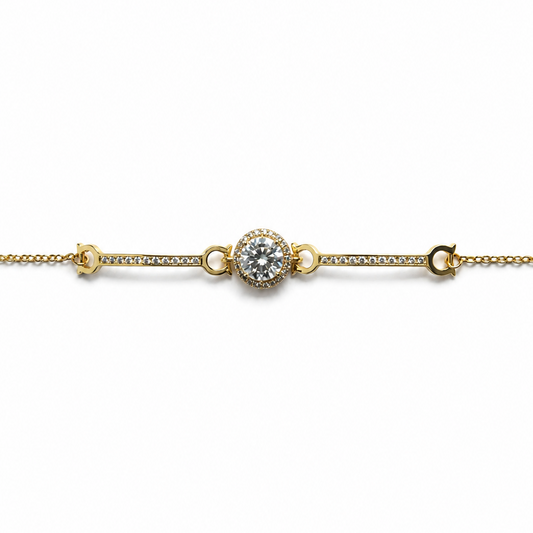 Gold bracelet with a central diamond on a white background