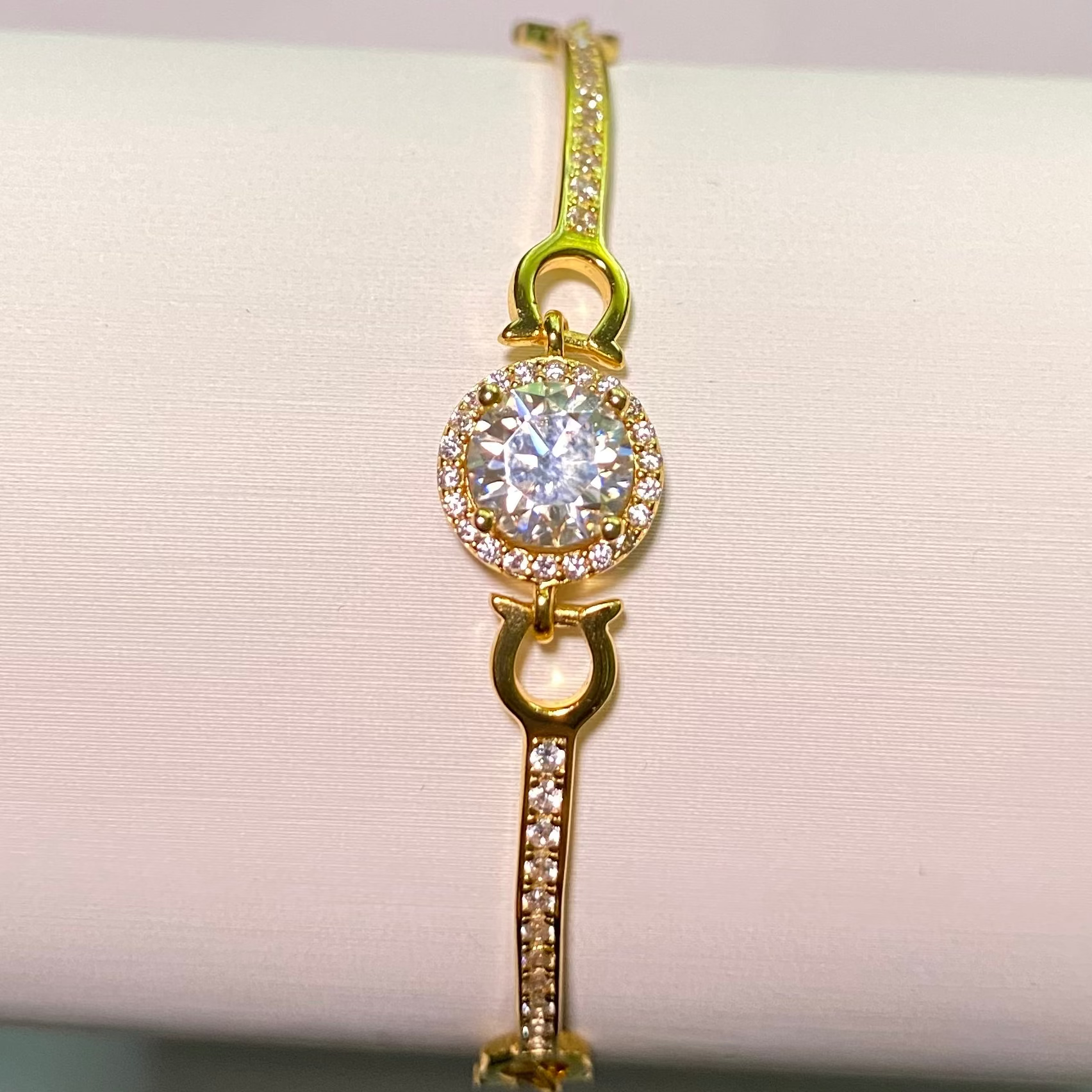 Gold bracelet with a diamond on a white background