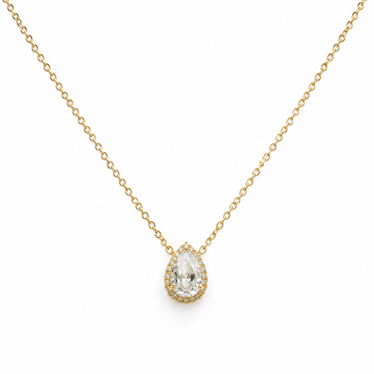 Gold necklace with a teardrop-shaped diamond pendant on a white background